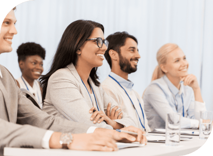 people attending a seminar smiling in suits